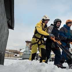 Уборка снега с плоской кровли альпинистами в Москве